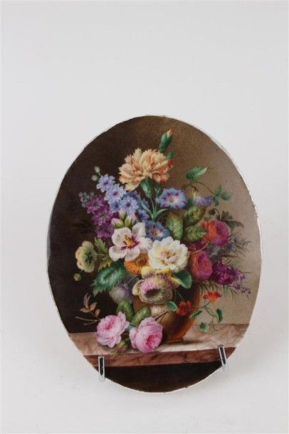 PARIS Plaque ovale en porcelaine à décor polychrome d'un bouquet de fleurs dans un...