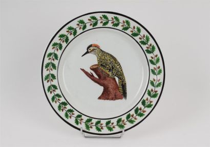 TOURNAI Assiette en porcelaine tendre à décor polychrome au centre d'un oiseau posé...