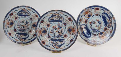 CHINE Suite de trois assiettes en porcelaine à décor imari de paysages dans des réserves....
