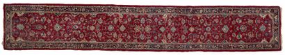 null TAPIS Galerie iranienne en laine à décor géométrique sur fond rouge.
 540 x...