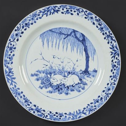 CHINE Plat rond en porcelaine à décor en bleu sous couverte de deux lapins sous un...