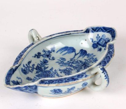 CHINE Saucière ovale à deux anses latérales en porcelaine à décor en bleu sous couverte...