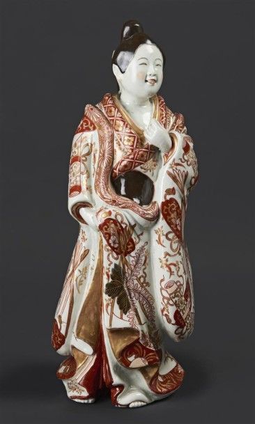 JAPON Statuette de Bijin en porcelaine, sa tunique à décor rouge et or dit Imari...