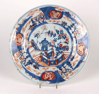 CHINE Plat rond en porcelaine à décor bleu, rouge et or dit Imari de pagode sur terrasse...