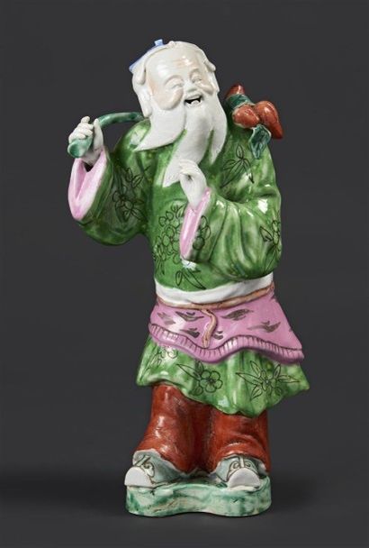 CHINE Statuette en porcelaine représentant un Immortel portant une branche garnie...