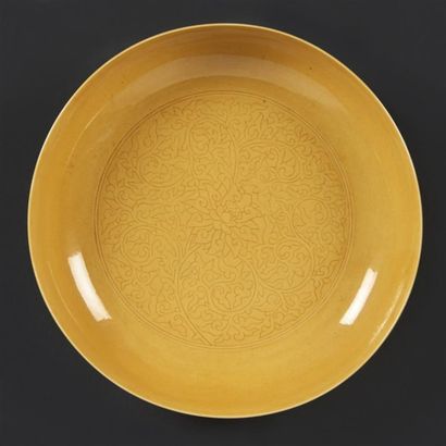 CHINE Coupe en porcelaine émaillée jaune à décor incisé de pivoines parmi des rinceaux...