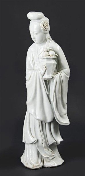 CHINE Statuette de Guanyin en blanc de Chine debout tenant un vase rempli de pêches.
XIXe...
