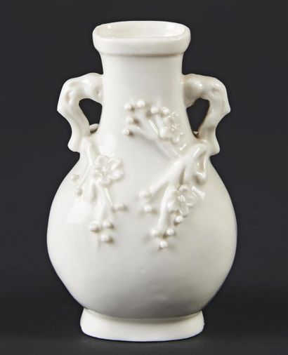CHINE Petit vase balustre en blanc de Chine à fleurs de prunus en relief, les anses...