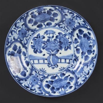 JAPON Plat rond en porcelaine d'Arita à décor en bleu sous couverte d'un vase fleuri...