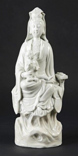 CHINE Statuette de Guanyin en blanc de Chine assise sur un rocher, tenant un enfant...