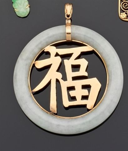 null PENDENTIF de forme ronde en jade, le centre décoré d'un caractère asiatique...