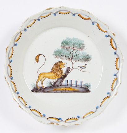 NEVERS Assiette à bord contourné à décor polychrome d'un lion hissé sur le tronc...