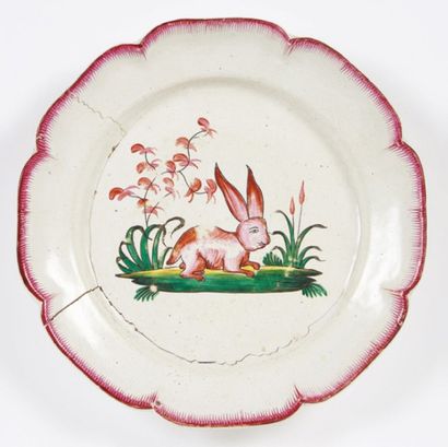 LES ISLETTES Assiette à bord lobé à décor d'un lapin rose couché sur une terrasse.
XIXe...