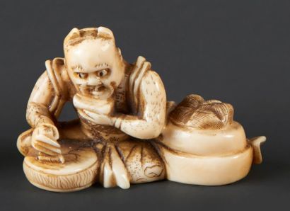 JAPON - Epoque MEIJI (1868 - 1912) Netsuke en ivoire, oni assis frappant un tambour....
