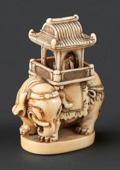 JAPON - Epoque MEIJI (1868 - 1912) Netsuke en ivoire, éléphant portant une petite...