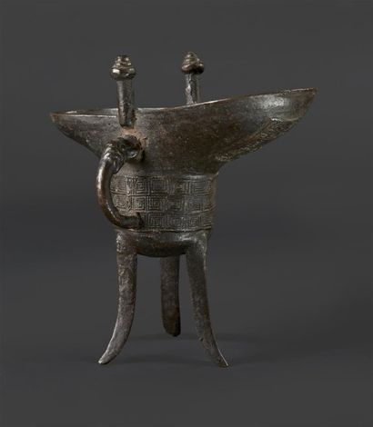 CHINE - XIXe siècle Vase à vin du type "jue" en bronze à patine brune, les côtés...