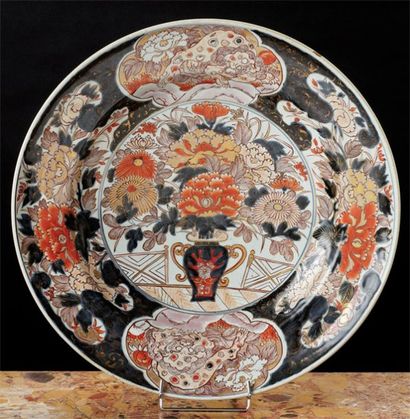 JAPON (Arita). Grand plat rond décoré dans la palette Imari d'un vase fleuri sur...