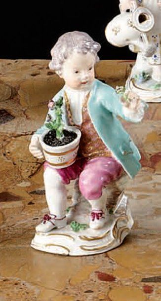 MEISSEN. Statuette d'un jeune homme assis sur des rochers tenant un vase de fleurs...