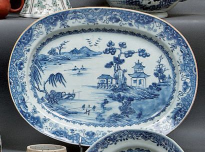 CHINE Plat ovale à décor en camaïeu bleu d'un paysage lacustre, sur l'aile fleurs...