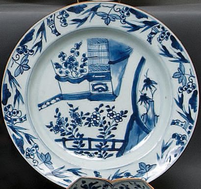 CHINE. Petit plat rond décoré en bleu sous couverte d'un paysage fleuri. XVIII° siècle....