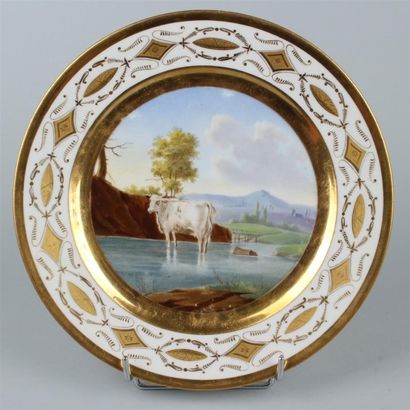 null PARIS. Assiette en porcelaine à décor polychrome au centre d'une vache dans...