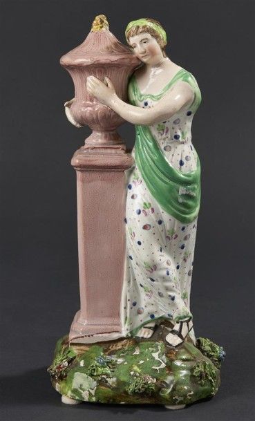 null EST. Statuette en faïence représentant une jeune femme appuyée contre un vase...