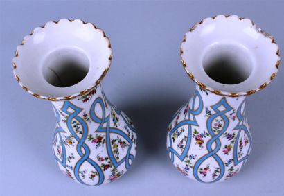 null PARIS. Paire de vases en porcelaines à décor floral et guirlandes bleu. Eclats...