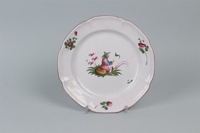 null EST. Assiette à bord contourné à décor polychrome d'un chinois assis sur un...