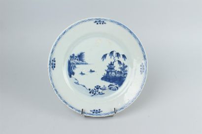 null CHINE - Assiette en porcelaine à décor en camaïeu bleu d'une une scène lacustre....