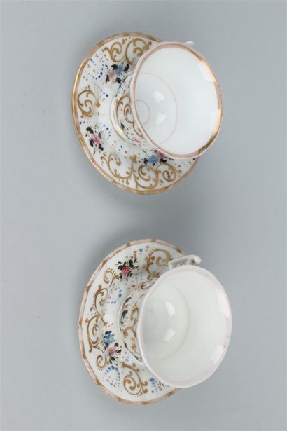 null PARIS 
Paire de tasses et sous tasses en porcelaine à décor polychrome de fleurs....