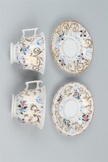 null PARIS 
Paire de tasses et sous tasses en porcelaine à décor polychrome de fleurs....