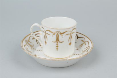 null PARIS - Tasse et sous tasse en porcelaine à décor de rinceaux dorés. 
XIXe siècle....