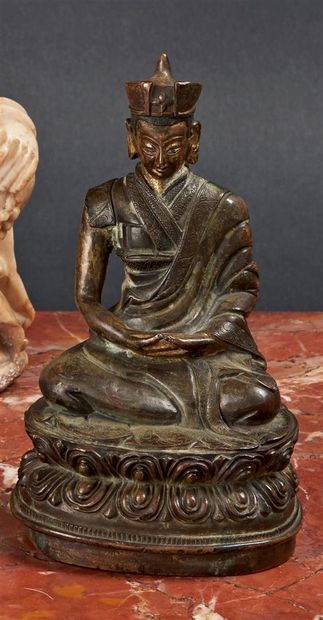 null TIBET - XIXe siècle
Statuette de lama en bronze à traces de laque or, assis...