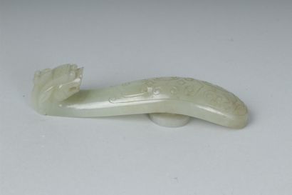 null CHINE 
Fibule en néphrite céladon sculptée en forme de chilong. (Egrenures)....