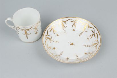 null PARIS
 Tasse et sous tasse en porcelaine à décor de rinceaux dorés. 
XIXe siècle....