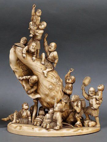 null OKIMONO en ivoire à patine jaune, pêcheurs et enfants montés sur un énorme coquillage....