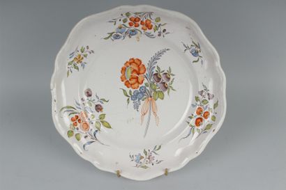 null FRANCHE-COMTE.
 Plat en faïence à bordure contournée à décor polychrome de fleurs...