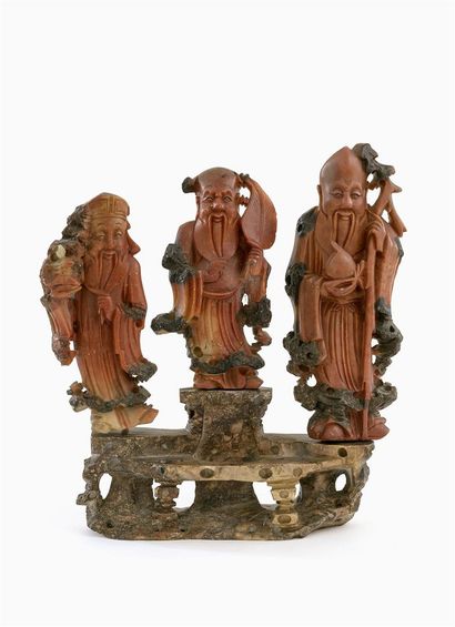 null CHINE, XXe siècle 
GROUPE en pierre sculptée rouge présentant trois personnages...