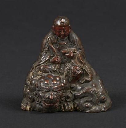 null JAPON - XIXe siècle
Petit groupe en bronze à patine brune, divinité assise sur...