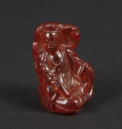 null CHINE - XIXe siècle
Petite statuette en ambre de guanyin assise contre un rocher,...