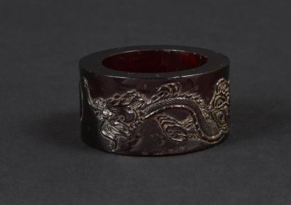 null CHINE - 
Bague d'archer en ambre à décor tournant d'un dragon à la recherche...