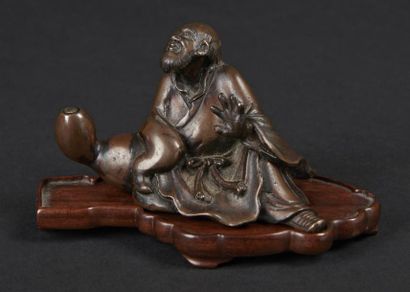 null CHINE - 
Petit sujet en bronze représentant un homme assis. Socle en bois. 
Dim....