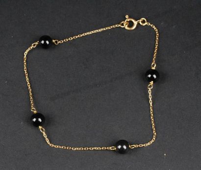 null BRACELET en or jaune 18K (750°°/oo) orné de quatre perles de couleur noire.
Longueur:...