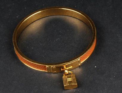 null HERMES Paris 
Bracelet jonc modèle "Kelly" en métal doré gainé de cuir fauve....