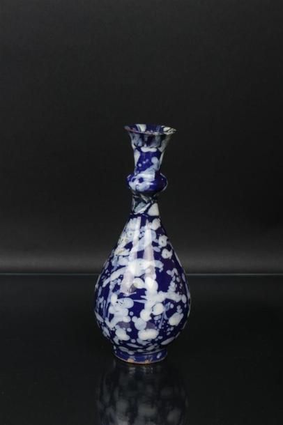 null NEVERS 
Vase de forme bouteille décoré en blanc fixe à la bougie sur fond bleu...