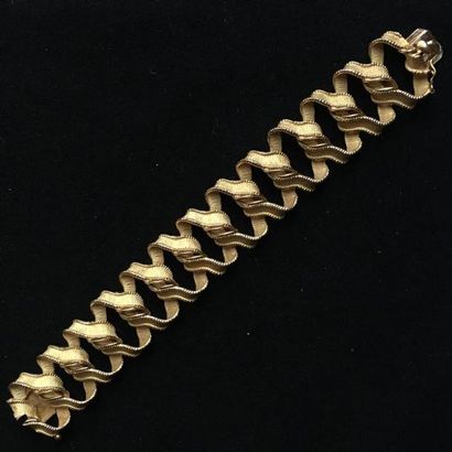 null Bracelet articulé en or jaune 750°/oo, les maillons entrelacés, gravés et amatis.
Longueur...