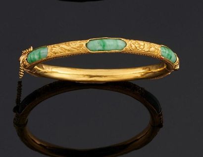 null Bracelet rigide ouvrant en or jaune 750°/oo gravé partiellement orné de jade.
(Bosses).
Diamètre...