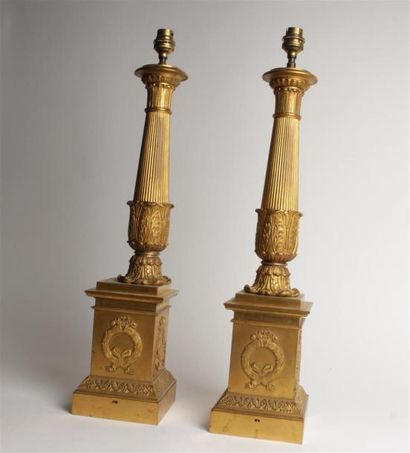 null PAIRE DE LAMPES en bronze doré, fût colonne à décor de cannelures et palmettes...