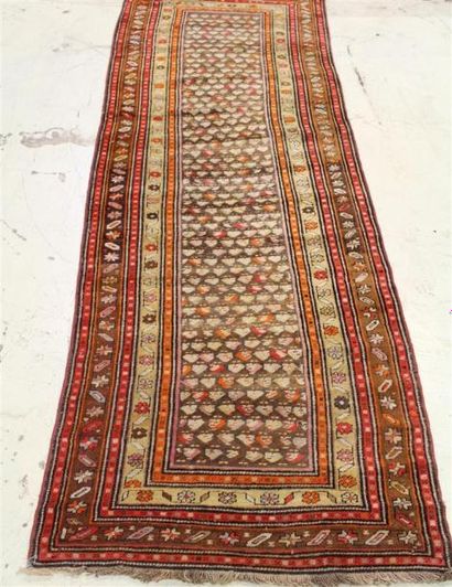 null KURDE
TAPIS GALERIE à décor stylisé sur fond marron, cinq frises d'encadrement....