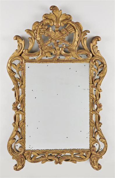 null MIROIR en bois doré à décor ajouré de feuillages et trophées de brandons au...